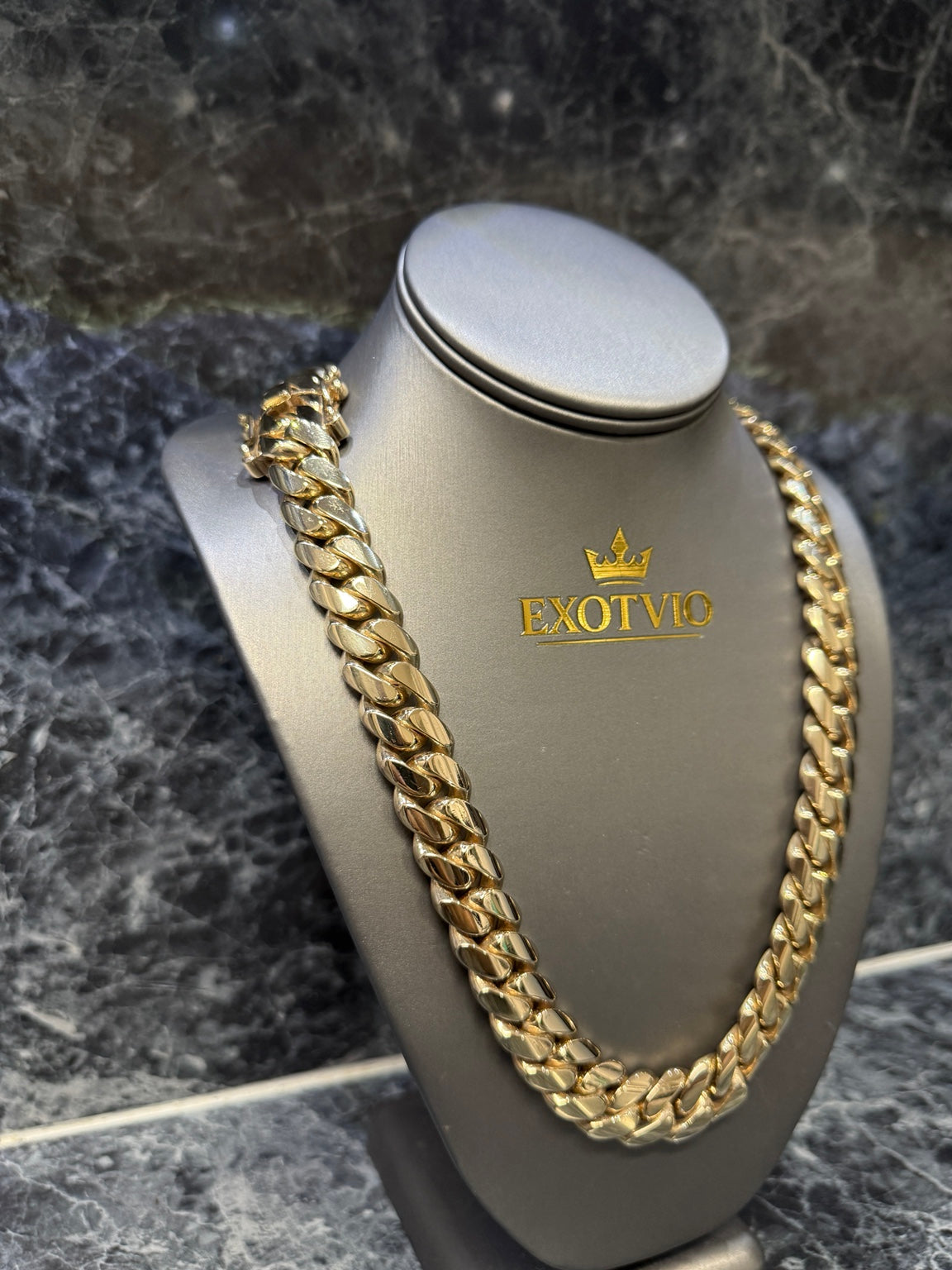 Close-up of Exotvio 16mm Heavy 14K Gold Bonded Miami Cuban link chain on display bust